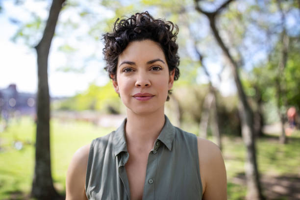 Portrait of a confident young woman standing at the park. Beautiful female in casuals looking at camera.